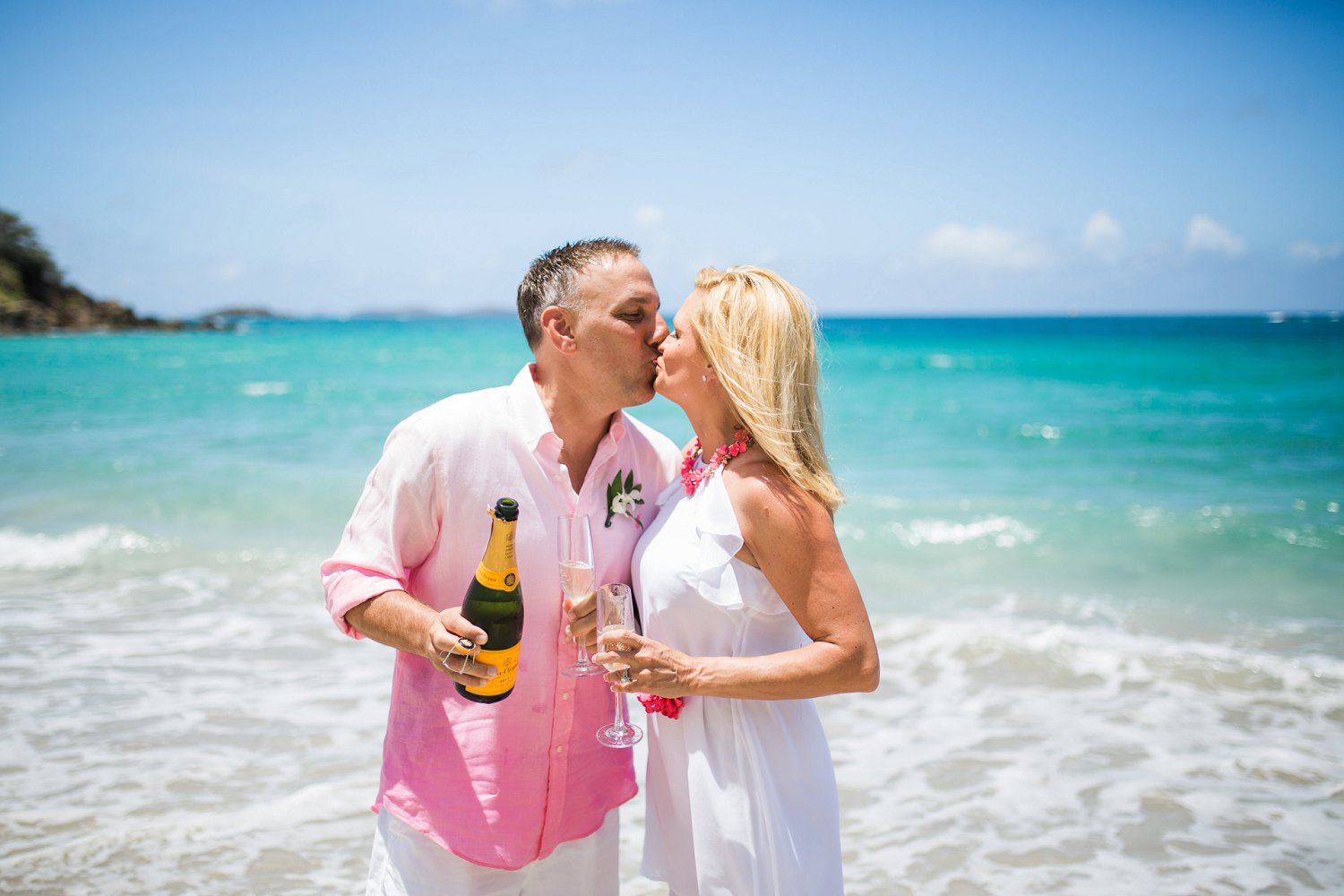Couple toasts 20 years with Vueve champagne on the beach.
