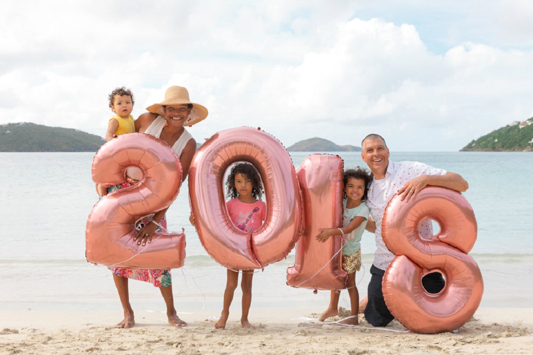 St. Thomas wedding planner Amber Ambrose of Blue Sky Ceremony and wedding minister Island Mike, Michael Motylinski pose for a 2018 family photo on the beach
