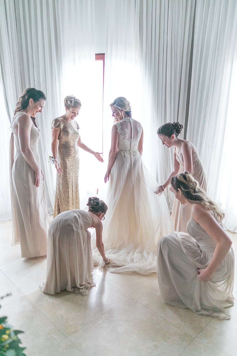 Bridesmaids help bride get dressed